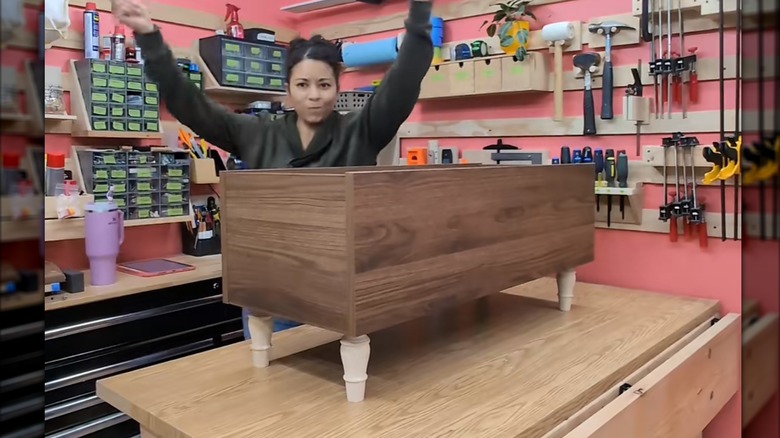 a bookcase on its back with furniture legs attached is the beginning of a stylish lift-top coffee table project