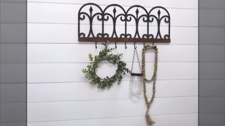 A shelf with hooks made from a Dollar Tree garden fence