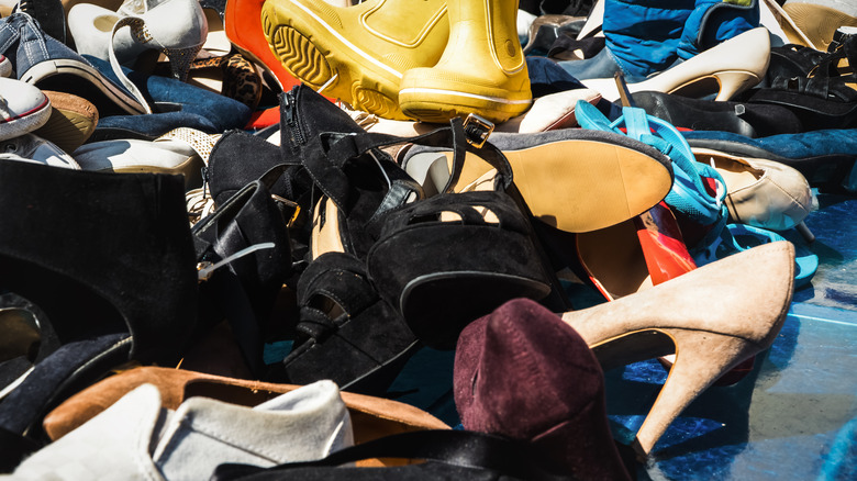 A pile of shoes in a messy closet