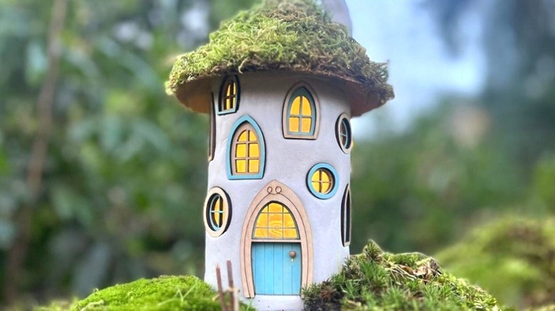 A fairy house made from an old glass jar and clay
