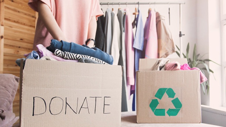 person packing clothes into a box for donating