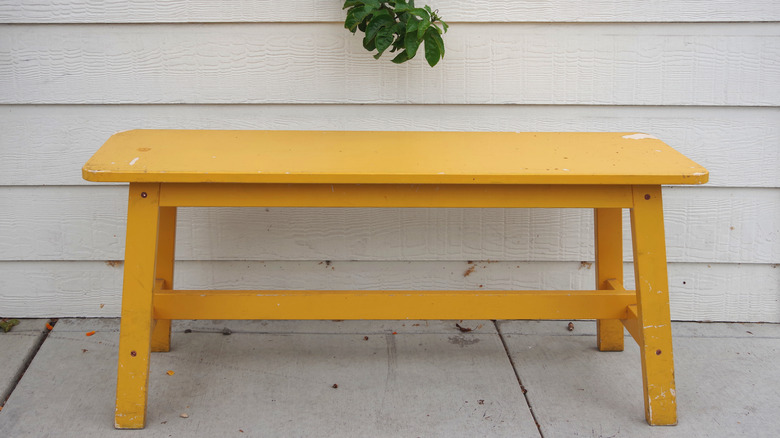 Yellow wooden bench on porch
