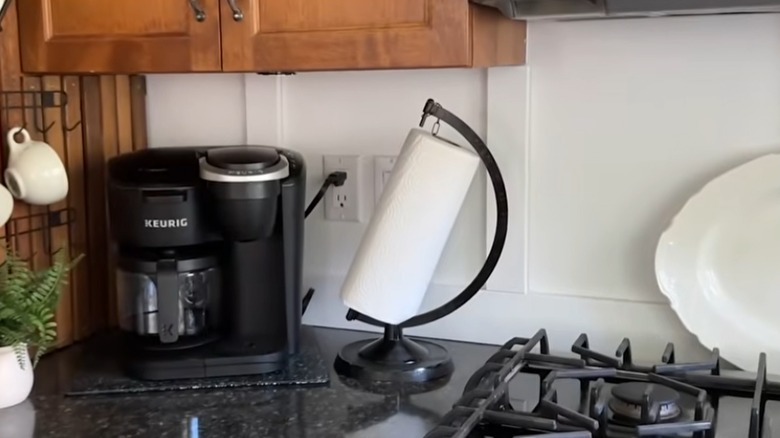 DIY paper towel holder made from a globe stand on kitchen countertop