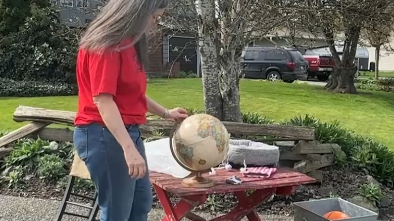 person with globe sitting on table outdoors