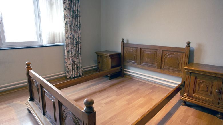 An antique wooden bed frame with a nice headboard.