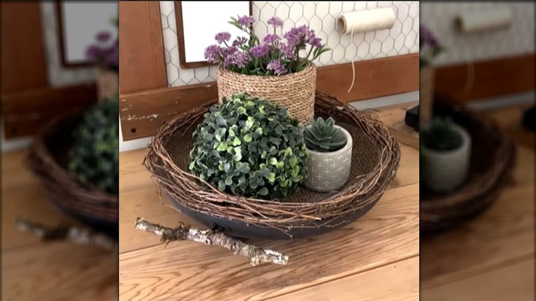 An upcycled pan is painted and decorated with natural fibers for use as a basket,