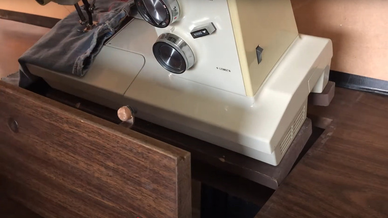 Removing a sewing machine from a cabinet