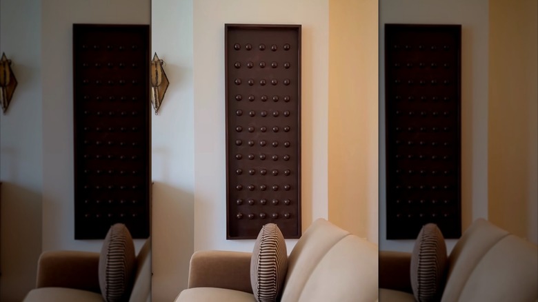 Dark-stained wooden wall art made with a wood plant and wood half spheres