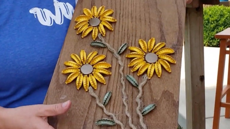 A woman holding sunflower DIY art