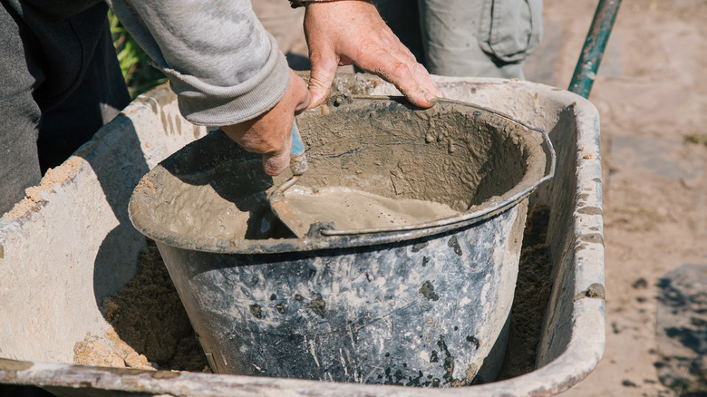 Someone preparing concrete for a project
