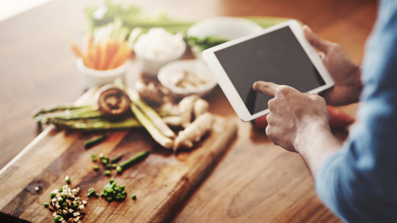 Male hand swiping through recipes on a tablet
