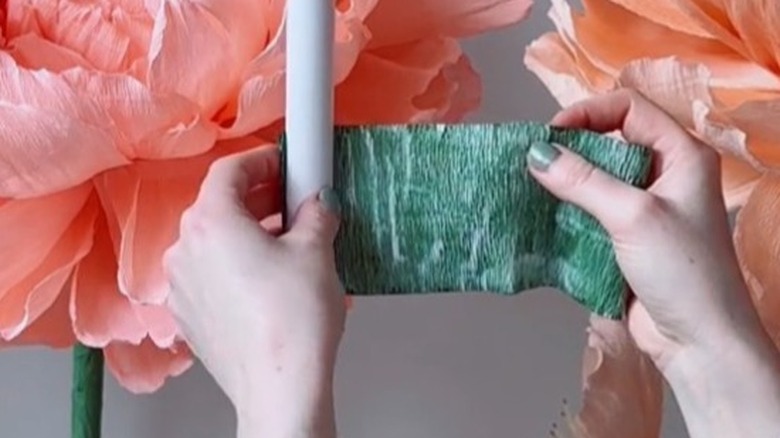 Wrapping green crepe paper over a white PVC pipe