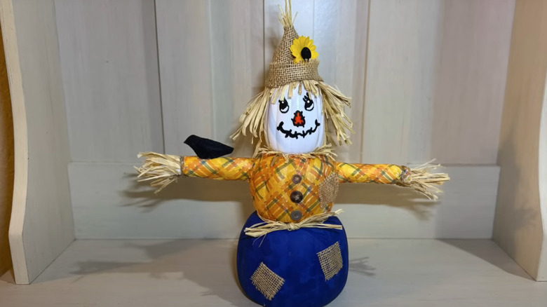 homemade scarecrow sitting on bench