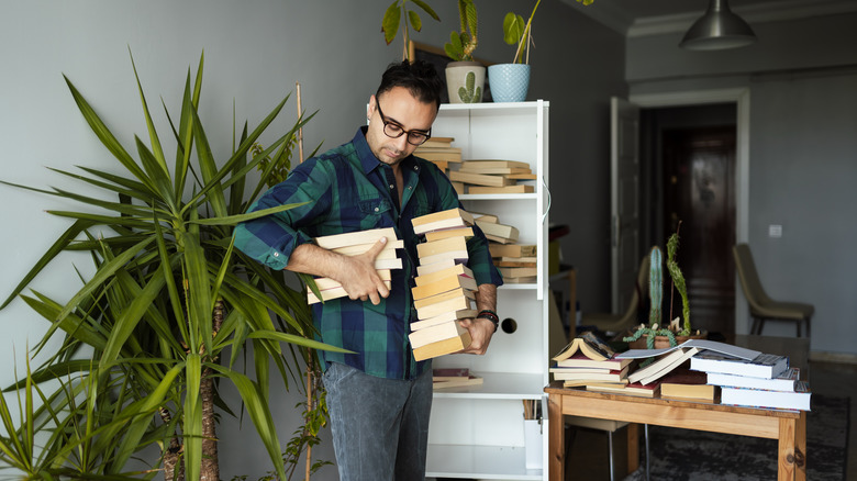 person with stacks of books