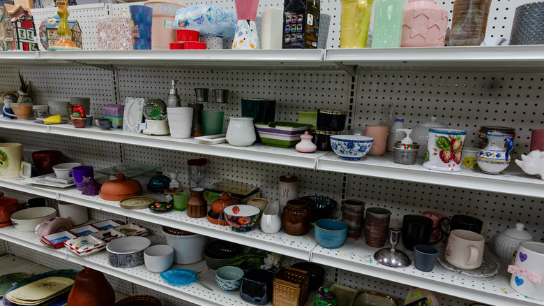 A shelf of bowls and other dishes at a thrift store