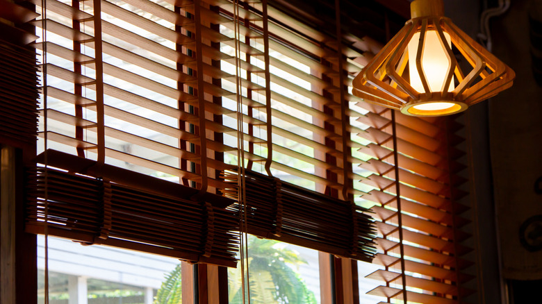 Light shining in a window through wood blinds