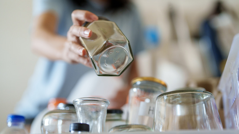 person sorting through old glassware