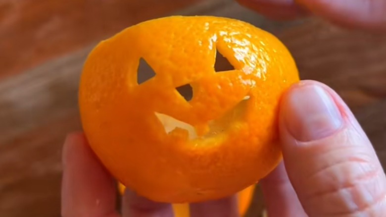 A Jack o lantern made from a small orange