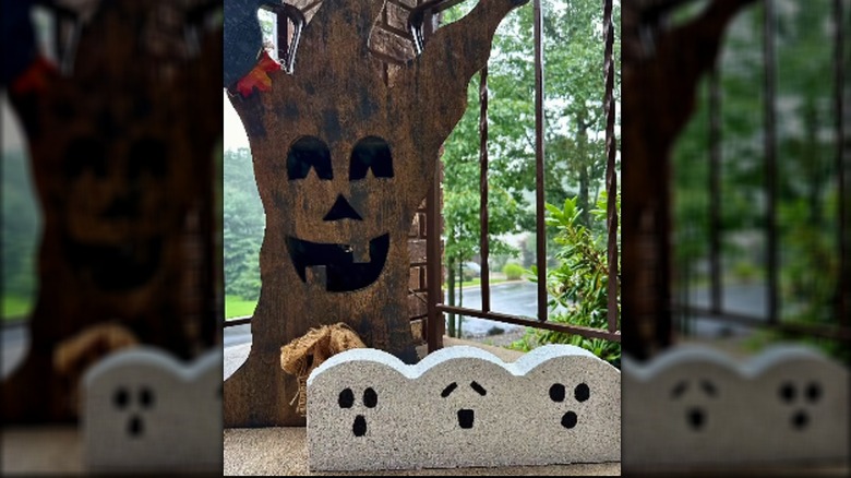 A scalloped brick edging paver is painted to look like three ghosts