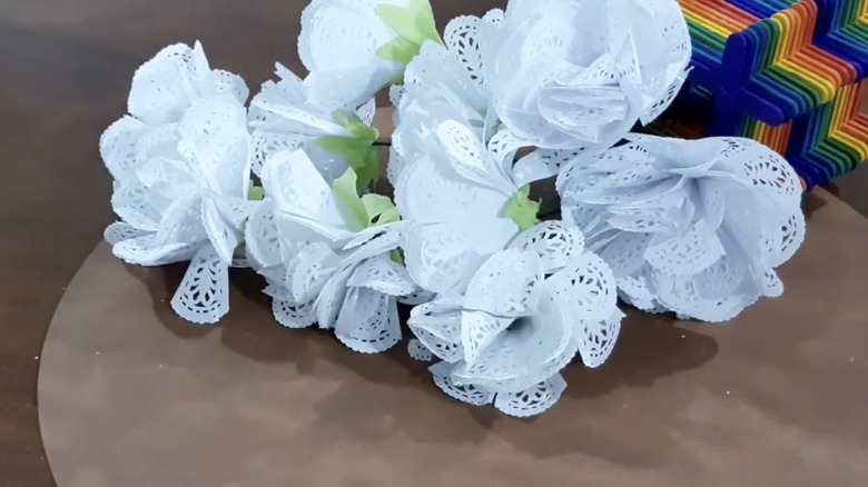 A bouquet of white carnation flowers made from paper doilies.