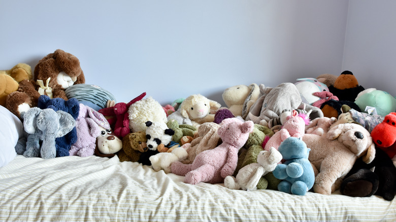 Lots of stuffed animals on bed