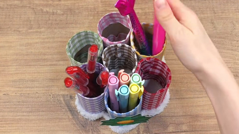 A pen holder storage DIY made with fabric and toilet paper rolls shown from above