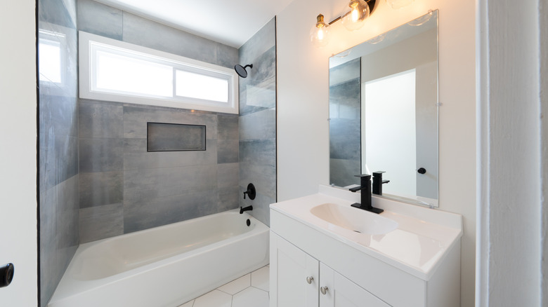 A minimal all-white bathroom with tiles in shower