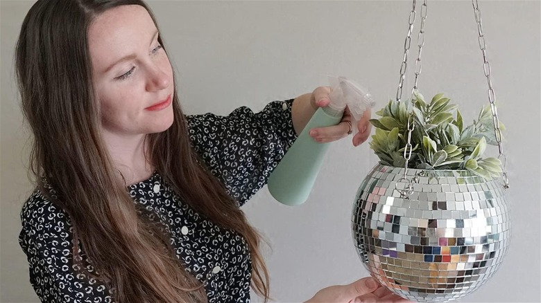 woman watering disco planter