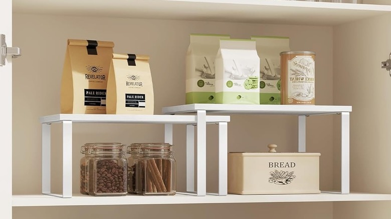 Shelf risers in a kitchen cabinet