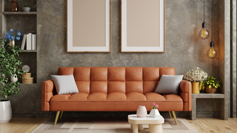 Modern living room with orange sofa against textured wallpaper