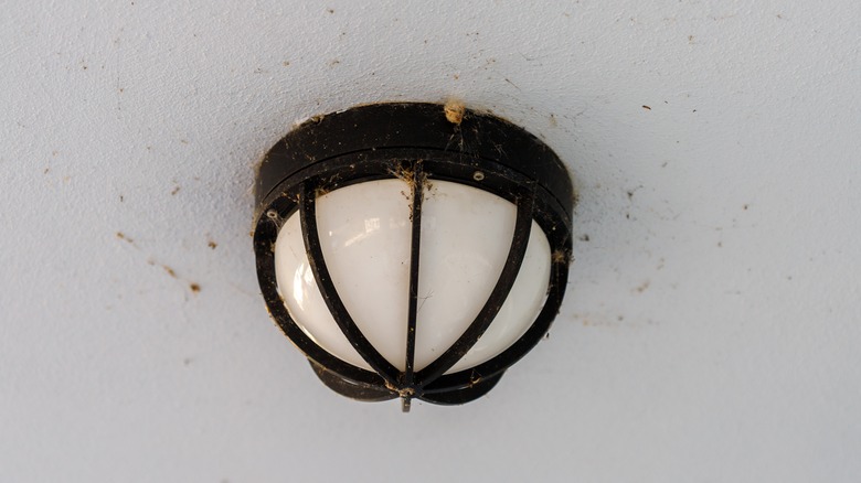 Dirty patio lighting mounted on the ceiling outdoors