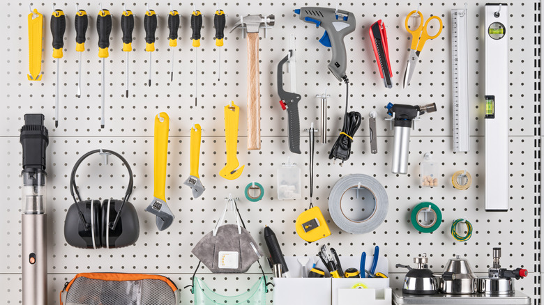 hand tools hanging on a white pegboard