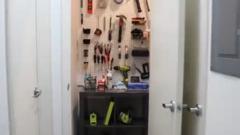 tools displayed on pegboard with shelves inside a closet