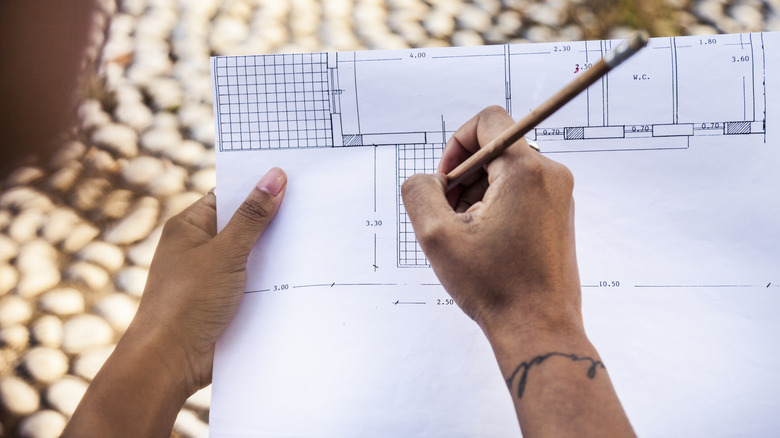 Person drawing plans for an outdoor fence