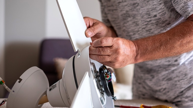 Close-up of a person repairing an old ceiling fan blade