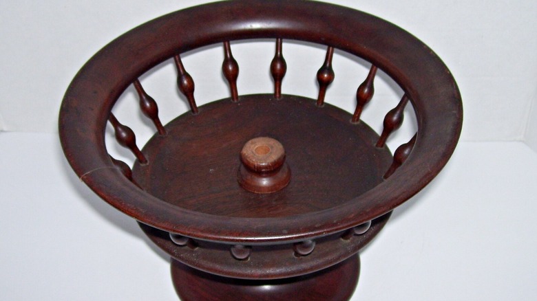 A wooden pedestal fruit bowl with a spindle base