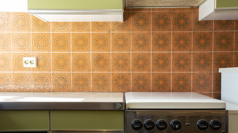 1970s kitchen with sage green cabinets and brown tile