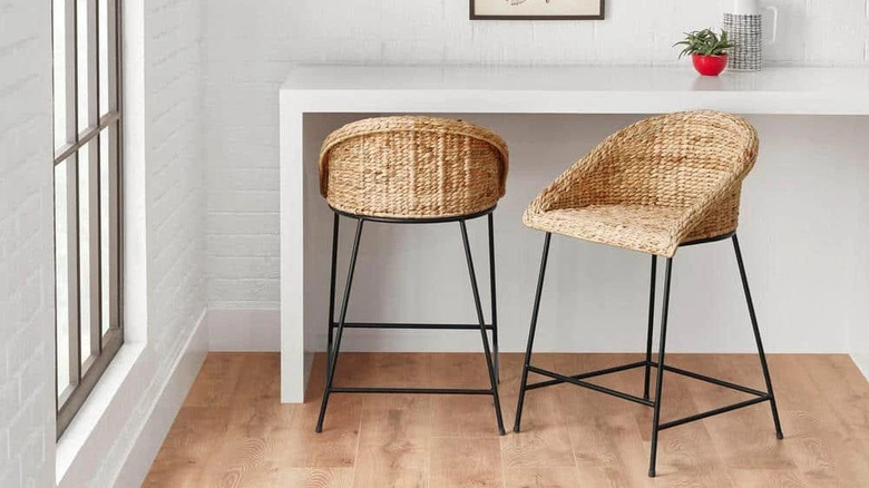 Woven counter stools with low back at modern white table