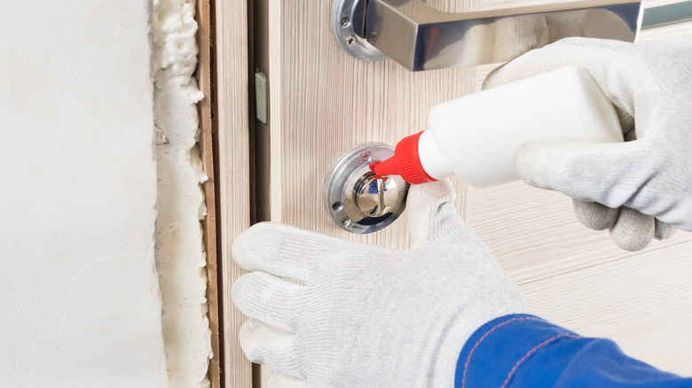 Someone lubricating a lock