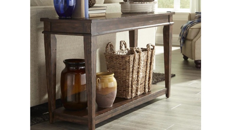 A table with tapered legs holding a basket and vases.