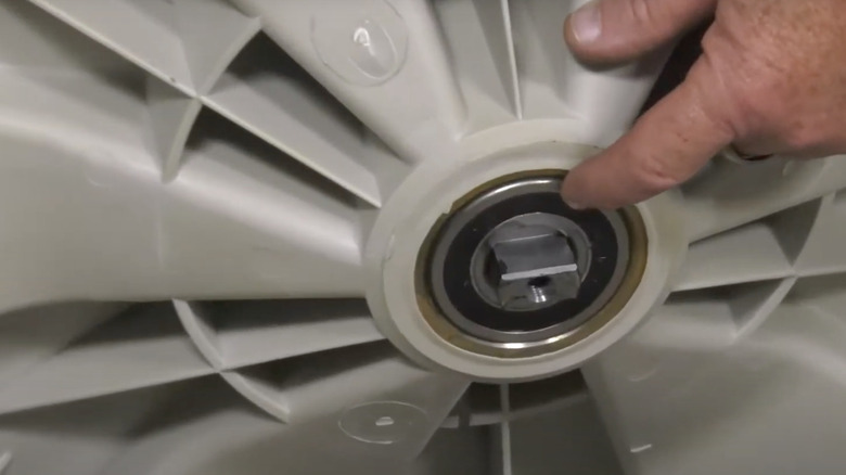 Hand pointing to tub bearing