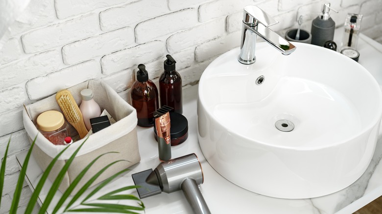 Hair and skincare products on small bathroom vanity