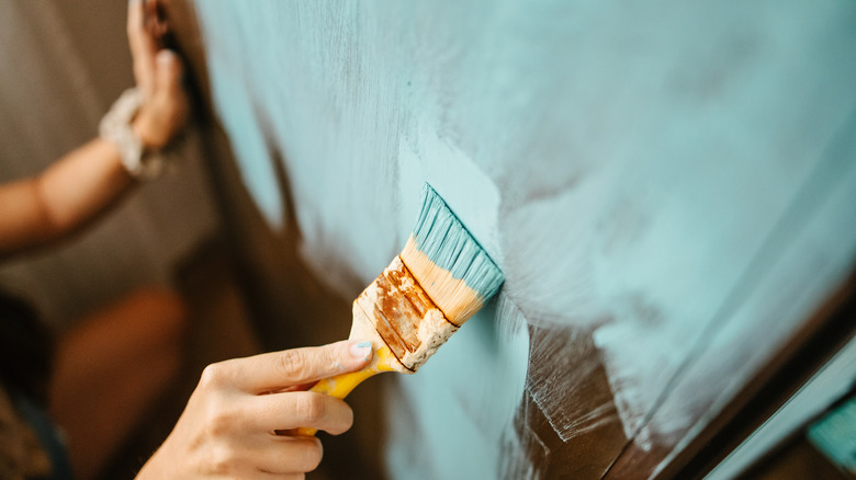 Person painting door