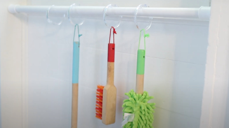 Cleaning tools hanging from tension rod