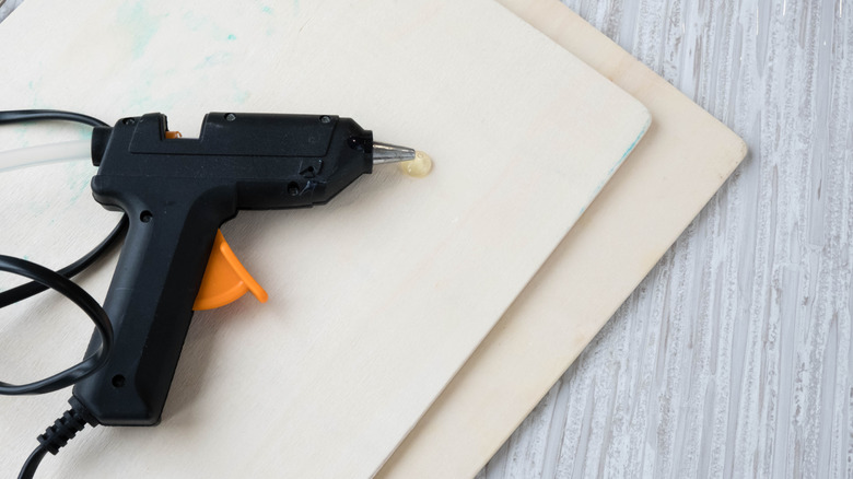Hot glue gun on two wooden boards