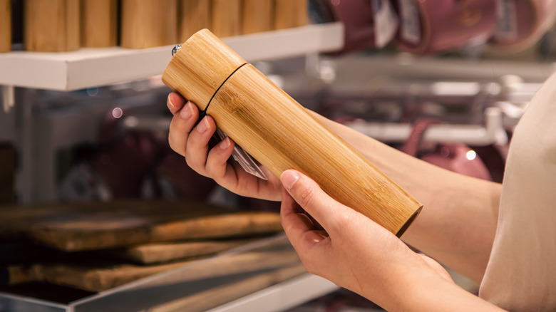 Woman shopping for wooden salt and pepper grinders