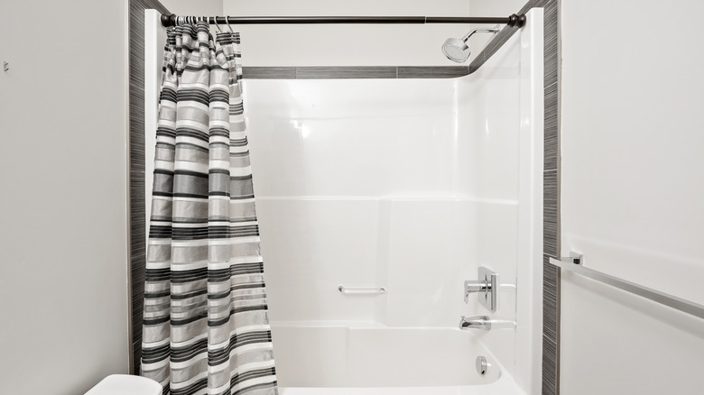 Bathroom with a shower curtain all on one side
