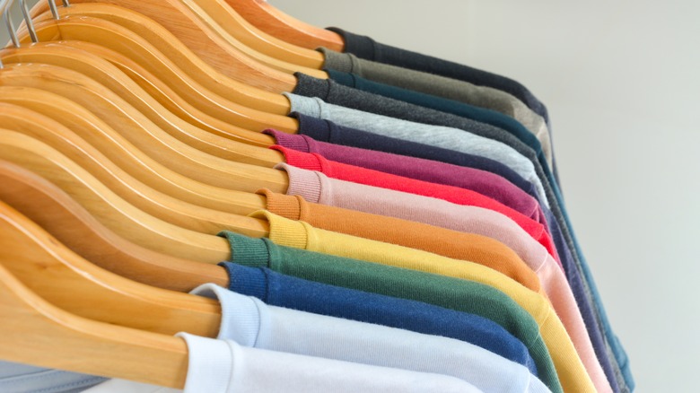 Colorful shirts on wood hangers