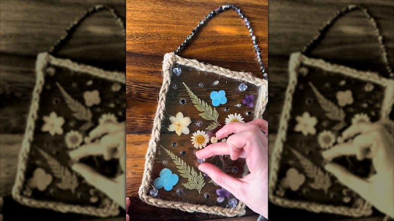 A crafter putting the finishing touches to a pressed flower suncatcher