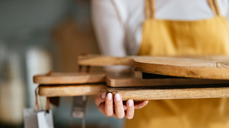 person holding multiple cutting boards